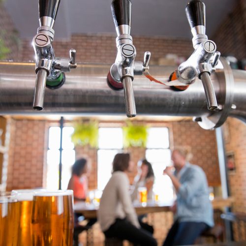 close-up-of-bar-beer-pumps-with-customers-drinking-2025-10-17-00-27-23-utc