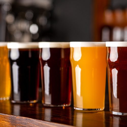 Beer assortment. Dark, light, unfiltered, lager and ale in glasses on wooden bar counter, close up, free space