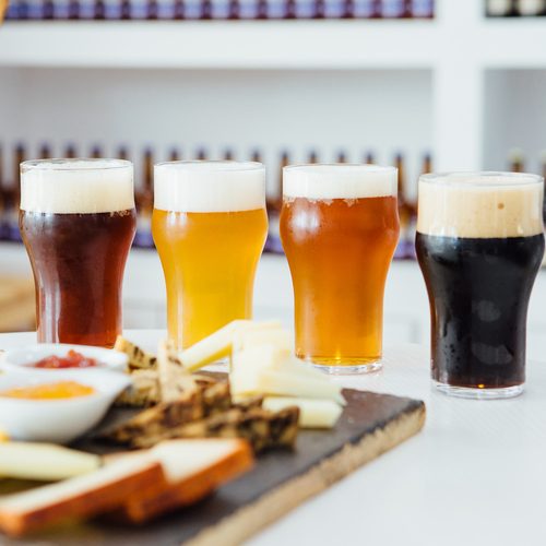 Close-up of four glasses of different craft beer with snack board