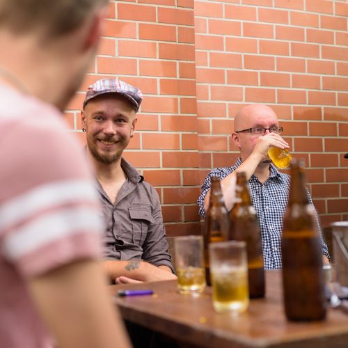 Group of Finnish men hanging out and relaxing together in the backyard at home